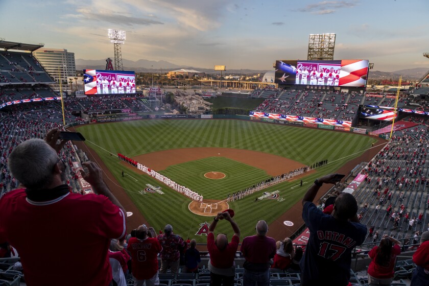 Fans stand for the national anthem before the Angels home opener against the Chicago White Sox at Angel Stadium.