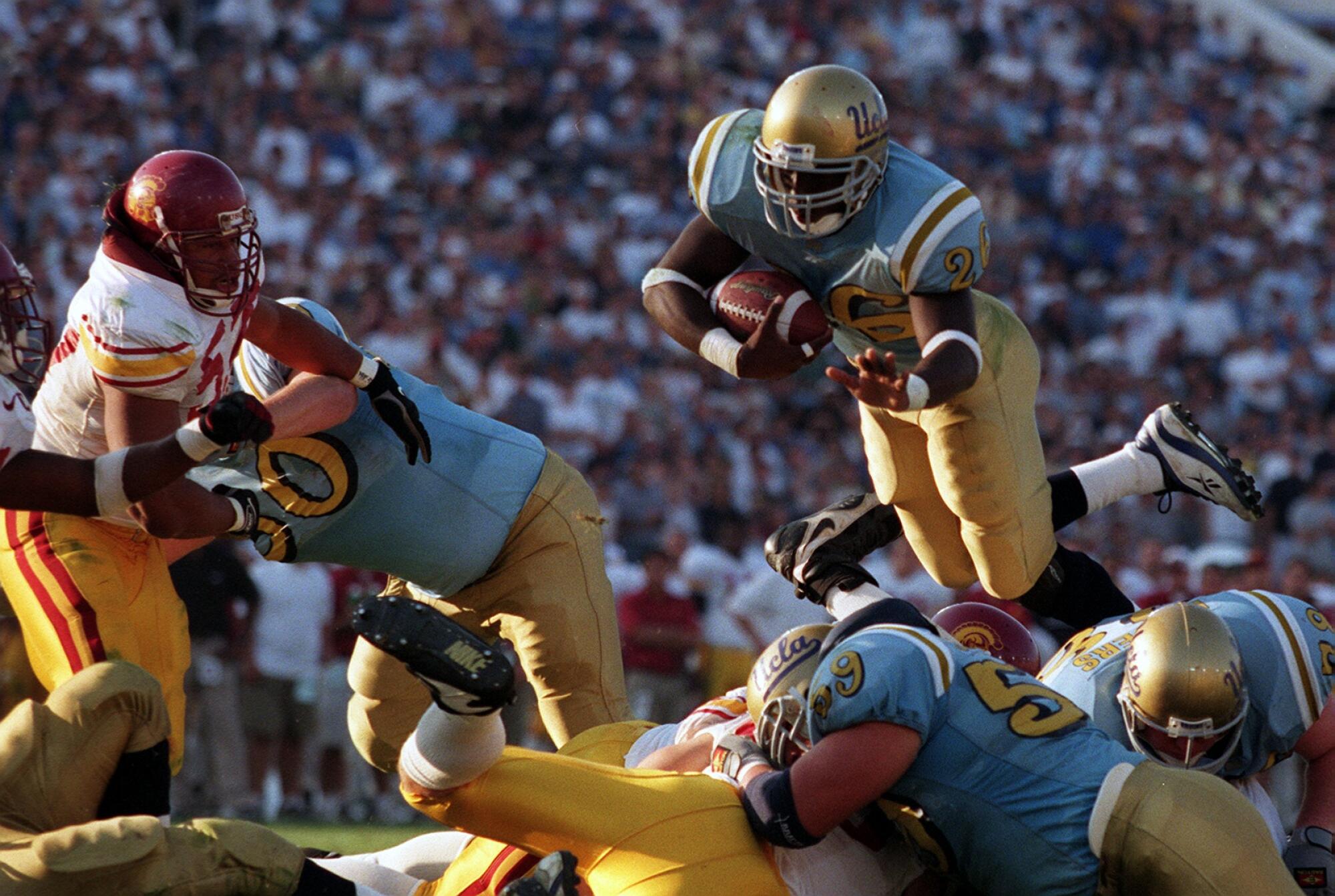 UCLA running back DeShaun Foster (26) leaps into the end zone for his fourth touchdown against USC.