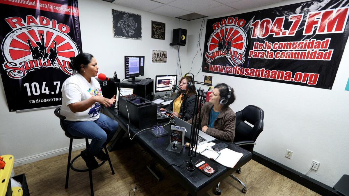 Carnaval Moralense USA organizer Dora Trejo, left, is interviewed at Radio Santa Ana by station coordinator and host Reyna Mendoza, center, and Socorro Torres Sarmiento during the morning news hour.