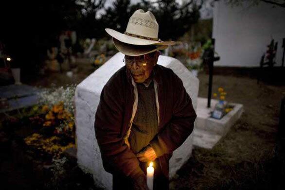 Santos Morales, 88, visits a relative's grave as part of the Day of the Dead celebrations at a cemetery in San Gregorio, Mexico.