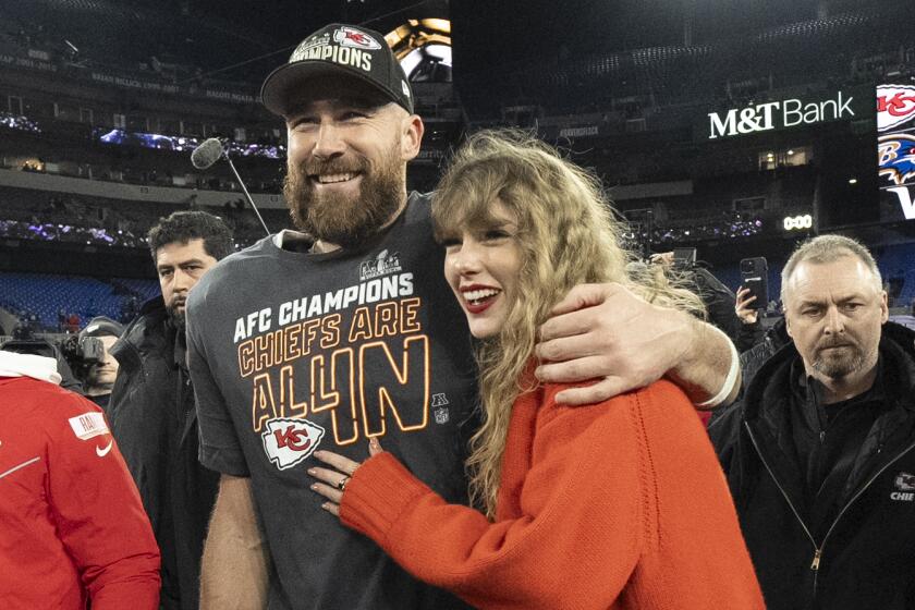 Kansas City Chiefs tight end Travis Kelce walks with Taylor Swift following the AFC Championship