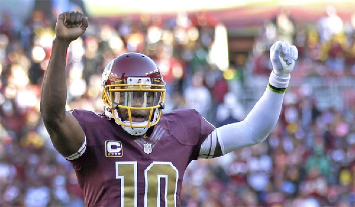 Washington quarterback Robert Griffin III raises his arms in celebration after a touchdown by fullback Darrel Young in the Redskins' 30-24 win over the San Diego Chargers in overtime Sunday.