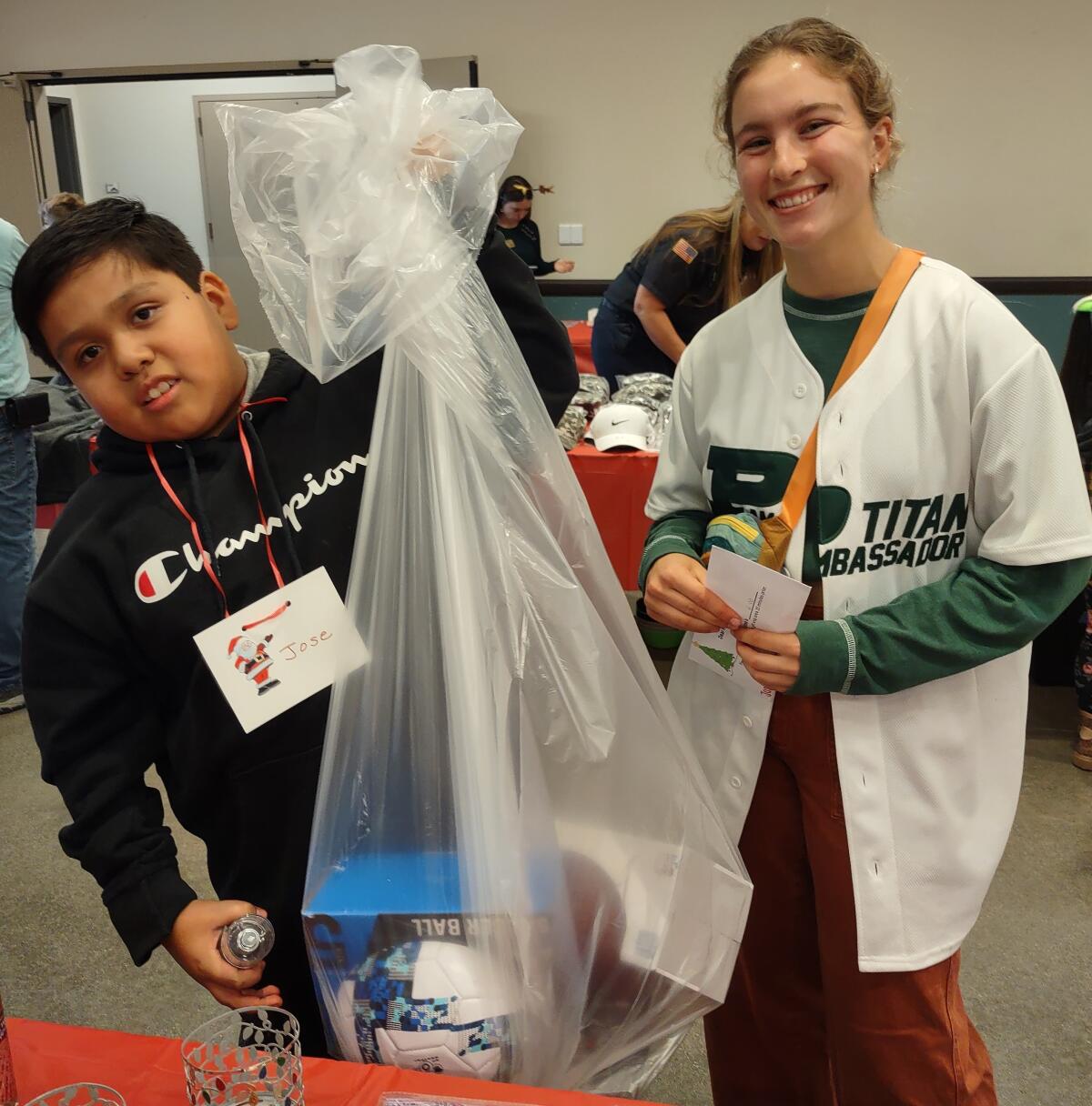 Jose Martinez and Anjolie Norton show off the bag of gifts they carried with them during Holiday with Heroes.