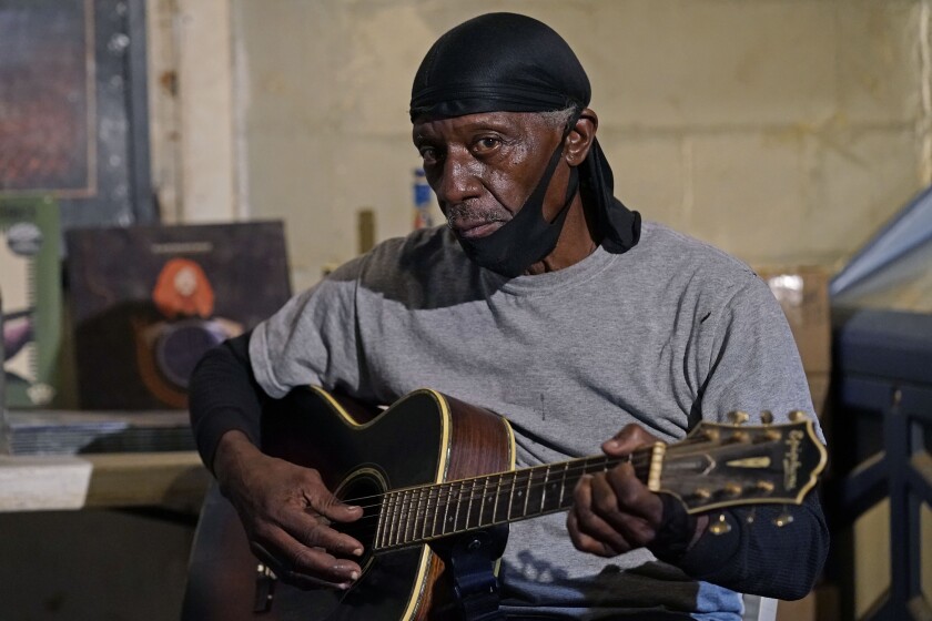 Bluesman Jimmy "Duck" Holmes plays a quick ditty at the Blue Front Cafe in Bentonia, Miss., Jan. 21, 2021. Holmes' ninth album, "Cypress Grove," has earned a Grammy nomination for the Best Traditional Blues Album. (AP Photo/Rogelio V. Solis)