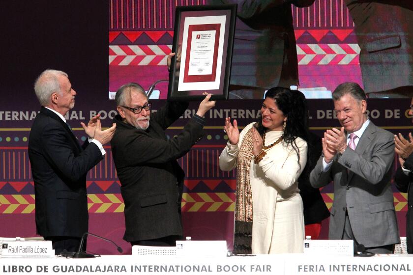 Mexican poet David Huerta (2-L) raises the Guadalajara International Book Fair's Literature in Romance Languages Award, next to the Secretary of Culture of Mexico Alejandra Frausto (3-L), the President of the Guadalajara International Book Fair Raul Padilla (L) and former Colombian president Juan Manuel Santos, during the inauguration of the Guadalajara International Book Fair, in Guadalajara, Mexico, on November 30, 2019. (Photo by Ulises Ruiz / AFP) (Photo by ULISES RUIZ/AFP via Getty Images)