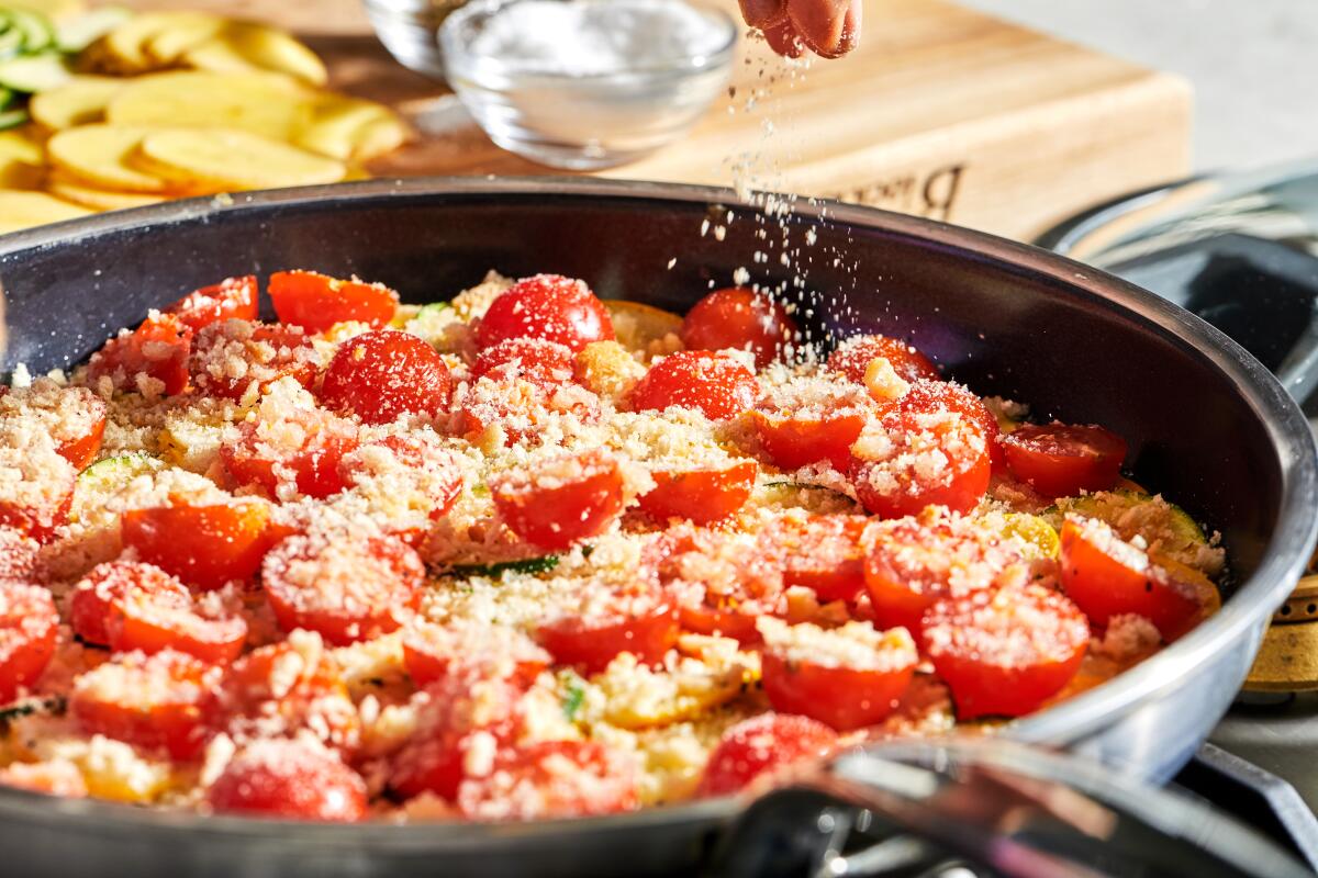 A vegetable tian cooks in a pan.