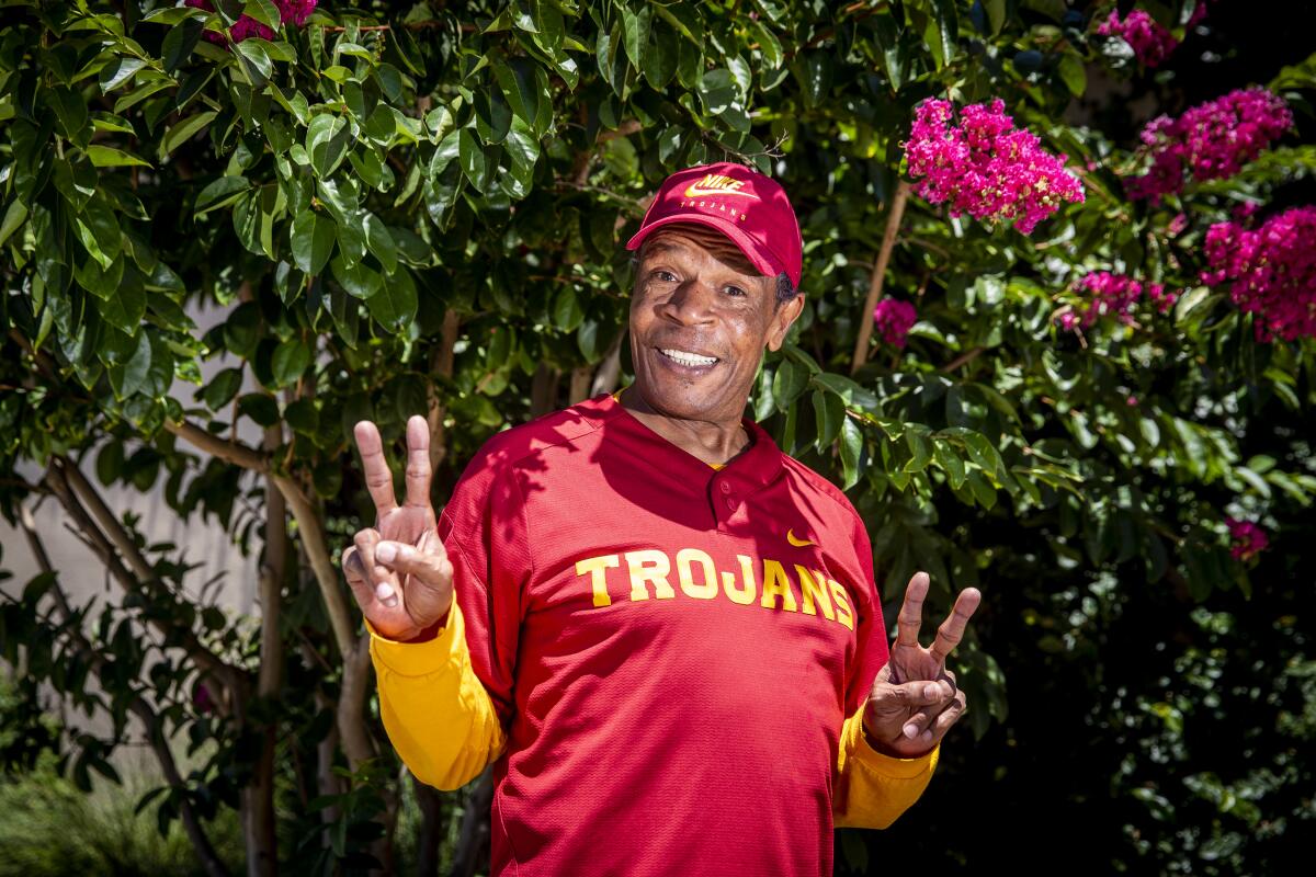 USC Heisman winner Charles White smiles while flashing the Trojans' victory sign.