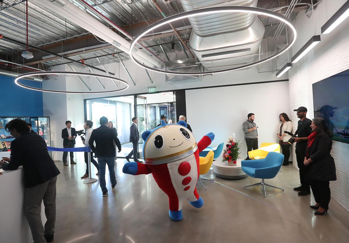 A Sega mascot walks through the lobby during the grand opening of Sega of America in Irvine.