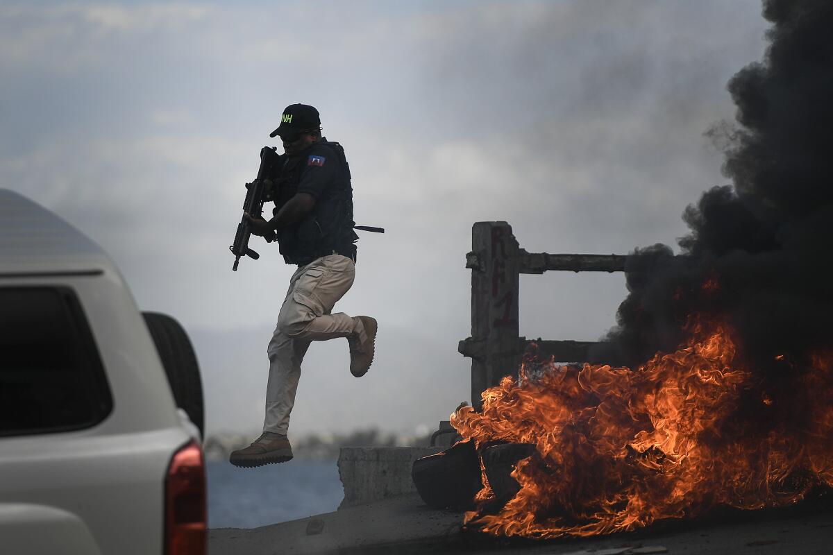 A police officer leaps from his vehicle alongside a burning roadside