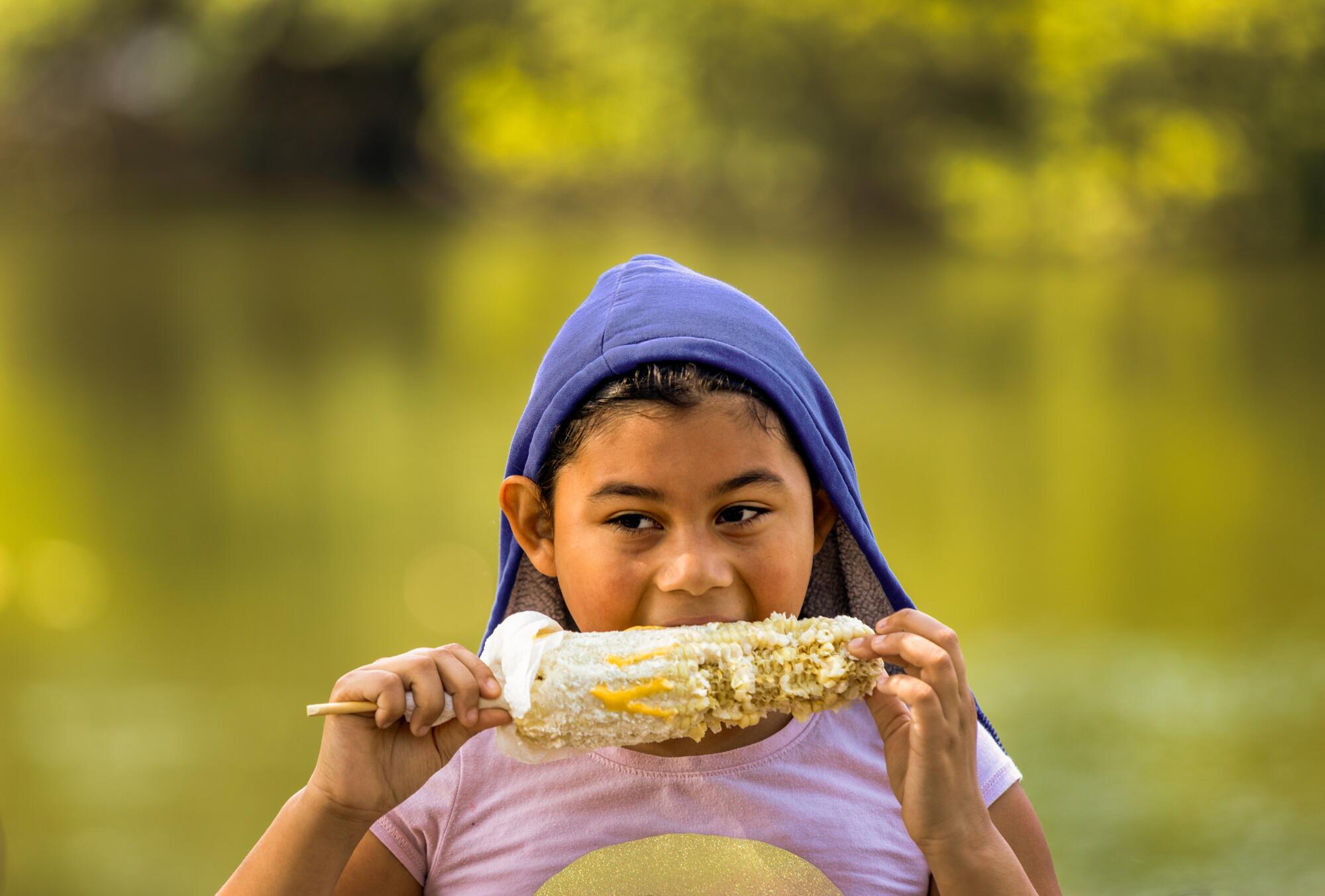 Giselle Castillo eating corn on the cob with mayonnaise, butter and cheese.