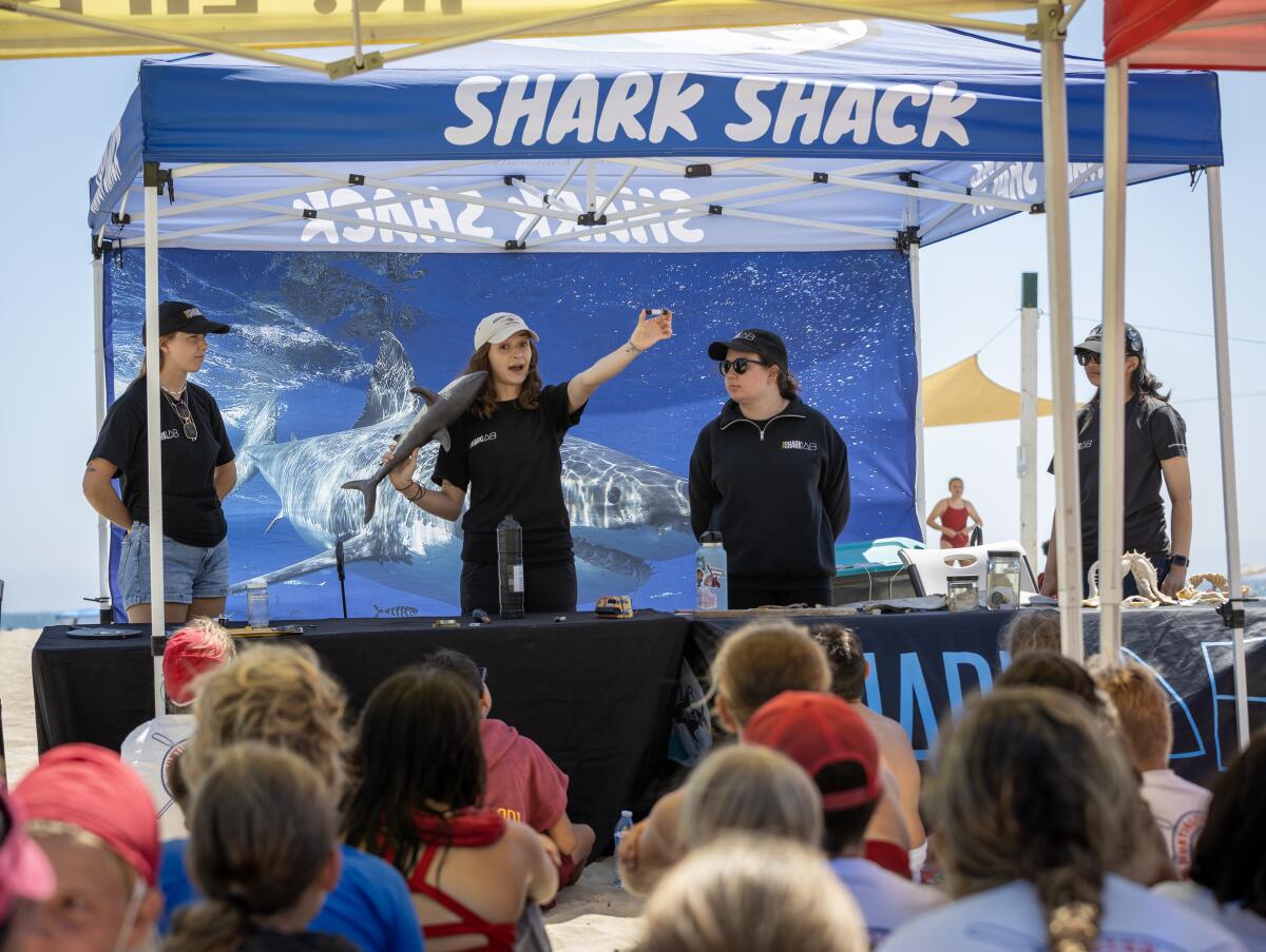 Shark Shack volunteers explain shark-tracking equipment during a presentation to Huntington Beach Junior Lifeguards.