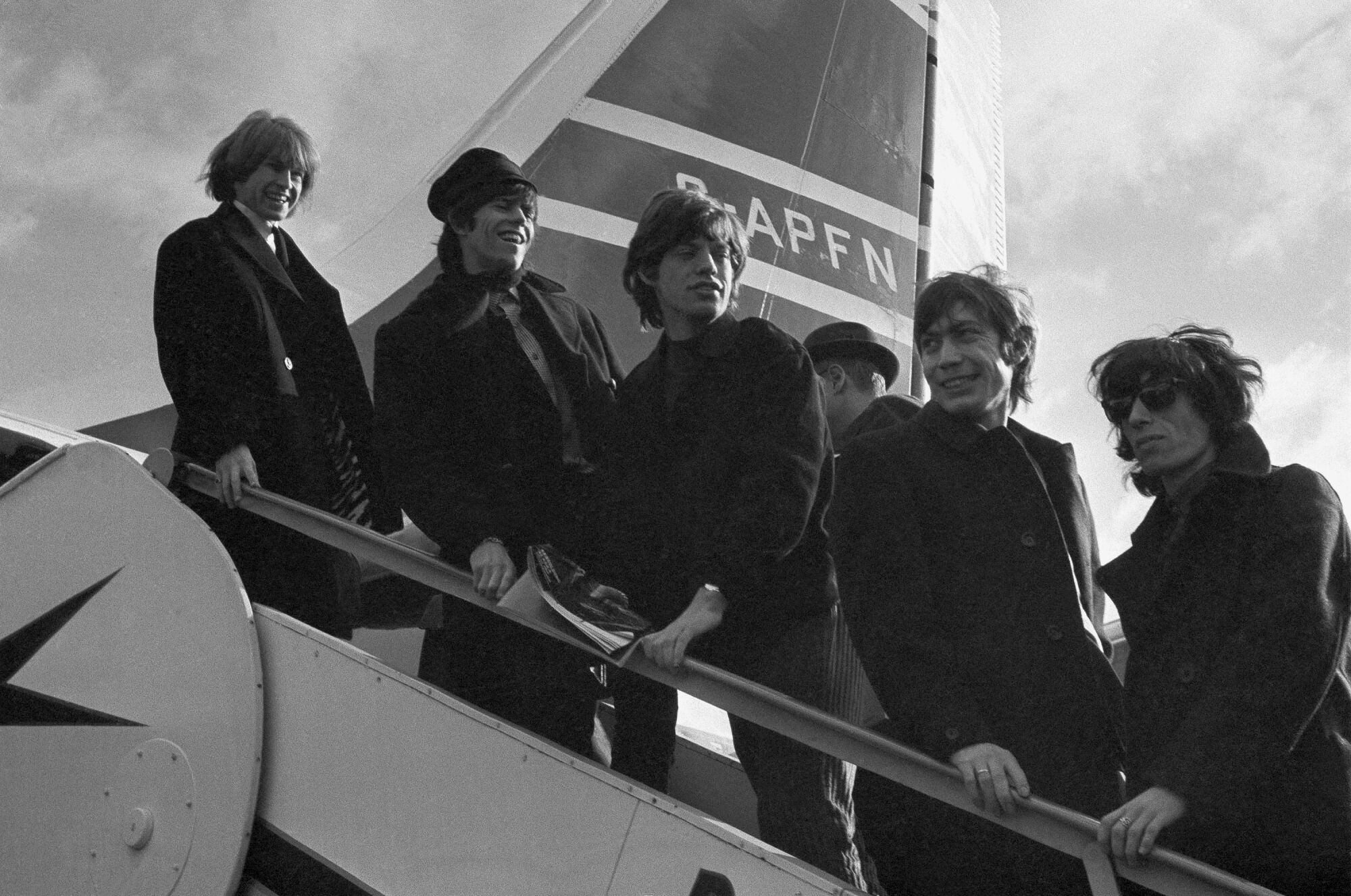 The Rolling Stones board a New York-bound plane at London Airport in 1964.
