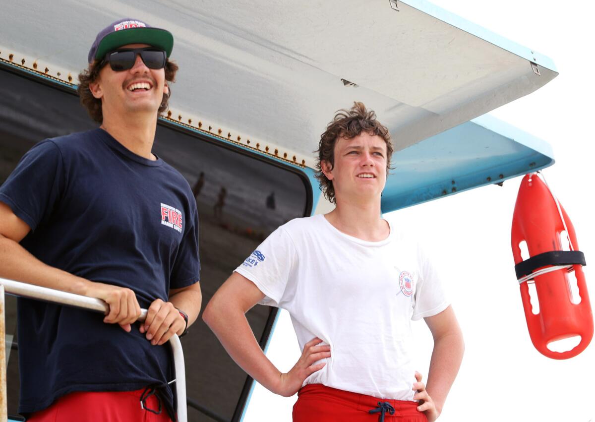 Huntington Beach Lifeguard Sam Smith and Illinois Cooney, a junior lifeguard visiting from Piha, New Zealand.