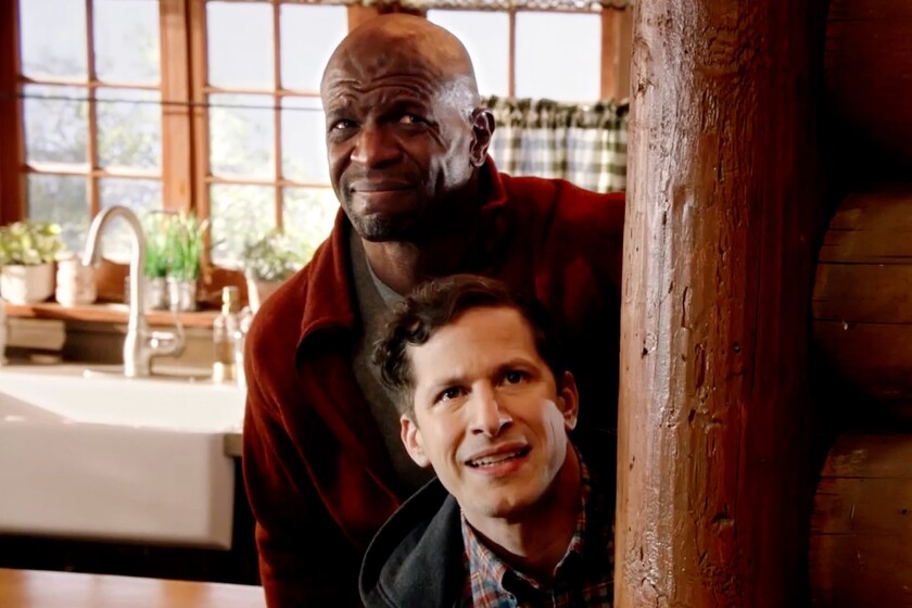 Terry Crews stands behind Andy Samberg in a doorway in "Brooklyn Nine-Nine" on NBC.