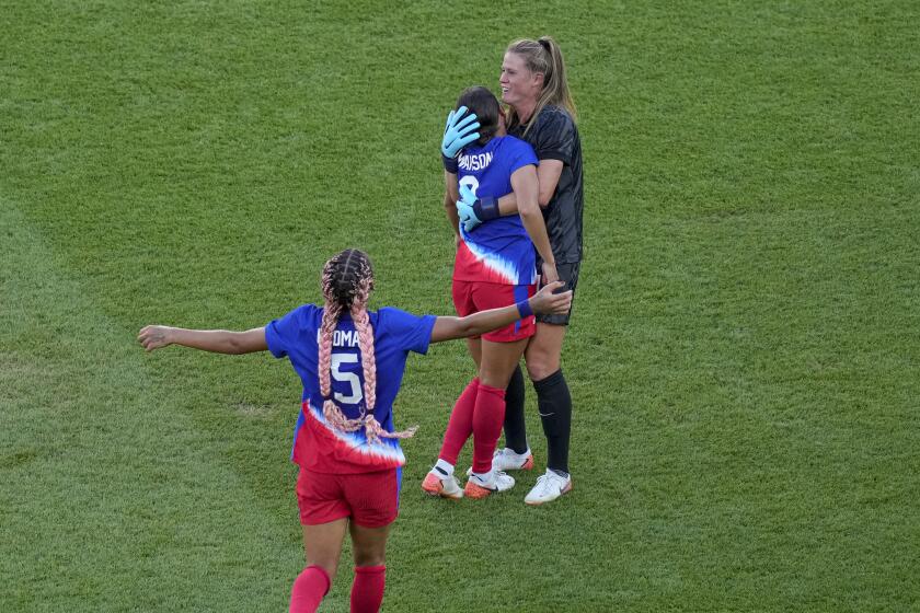 U.S. goalkeeper Alyssa Naeher hugs teammate Mallory Swanson as they celebrate winning a gold medal 