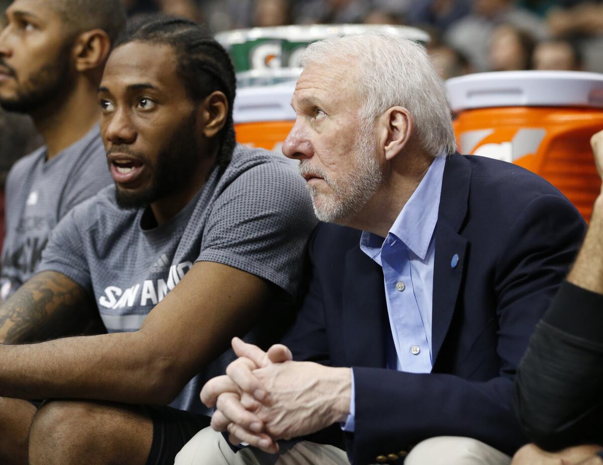 Spurs forward Kawhi Leonard and Coach Gregg Popovich talk during the second half of a game on Feb. 5.
