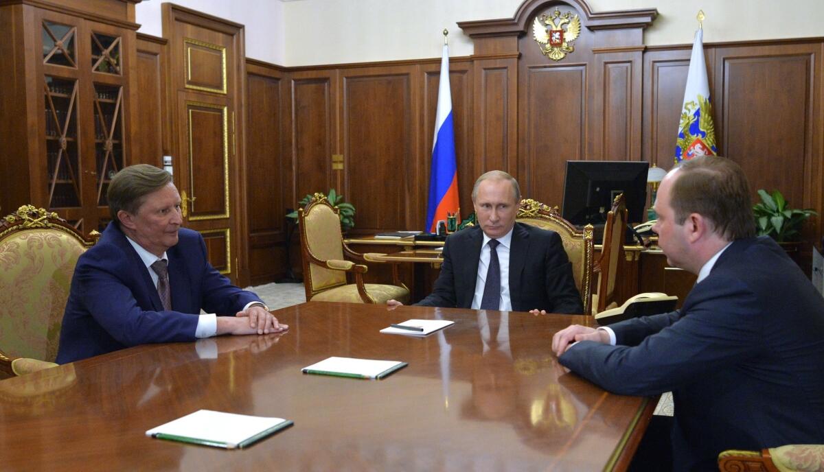 Russian President Vladimir Putin, center, meets with the new chief of the presidential administration, Anton Vayno, right, and the outgoing Kremlin chief of staff, Sergei Ivanov, in the Kremlin on Aug. 12, 2016.