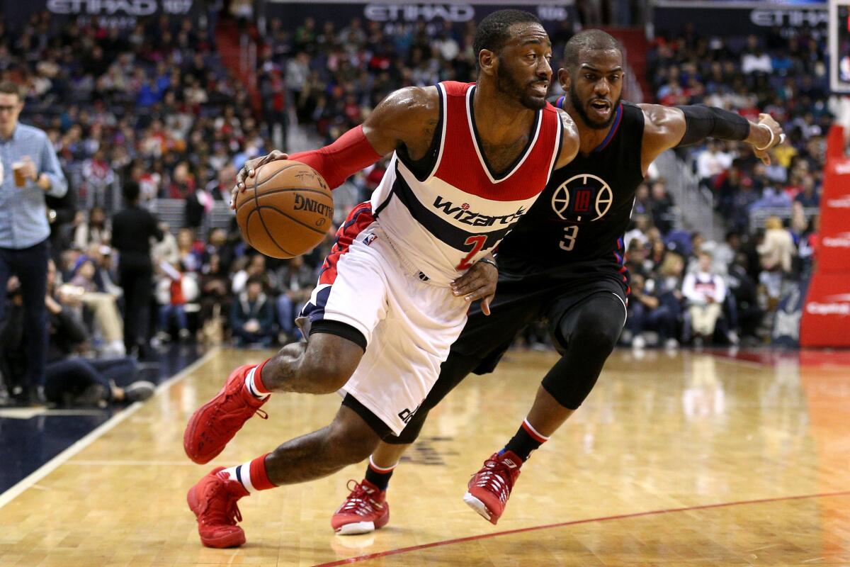 Wizards point guard John Wall drives past Clippers point guard Chris Paul during a game earlier this season (Patrick Smith / Getty Images)
