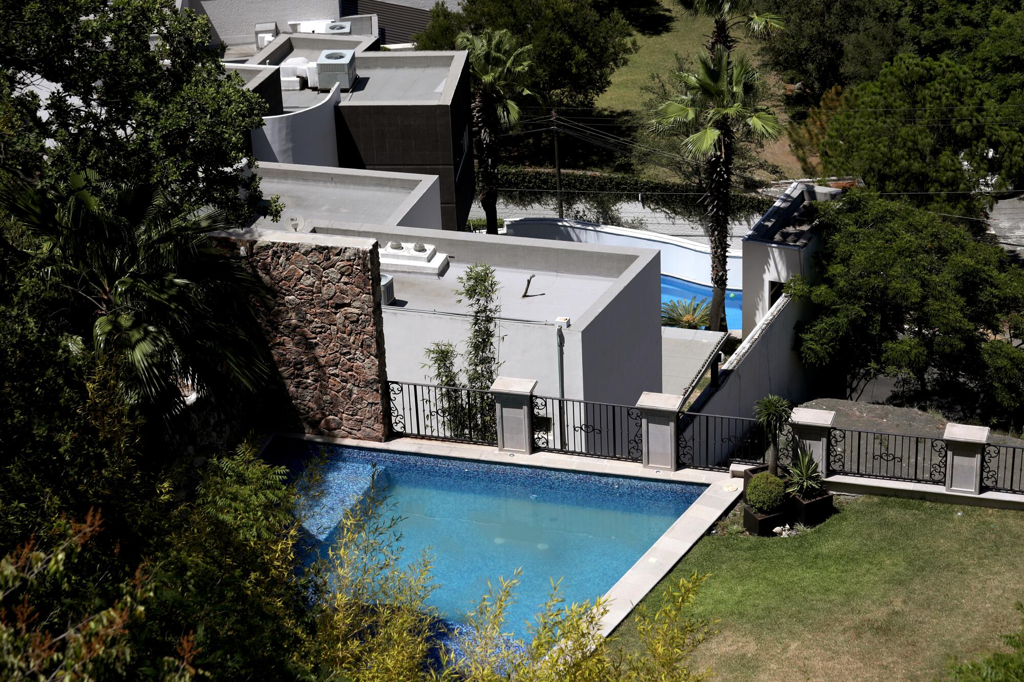 An overhead view of homes with swimming pools. 
