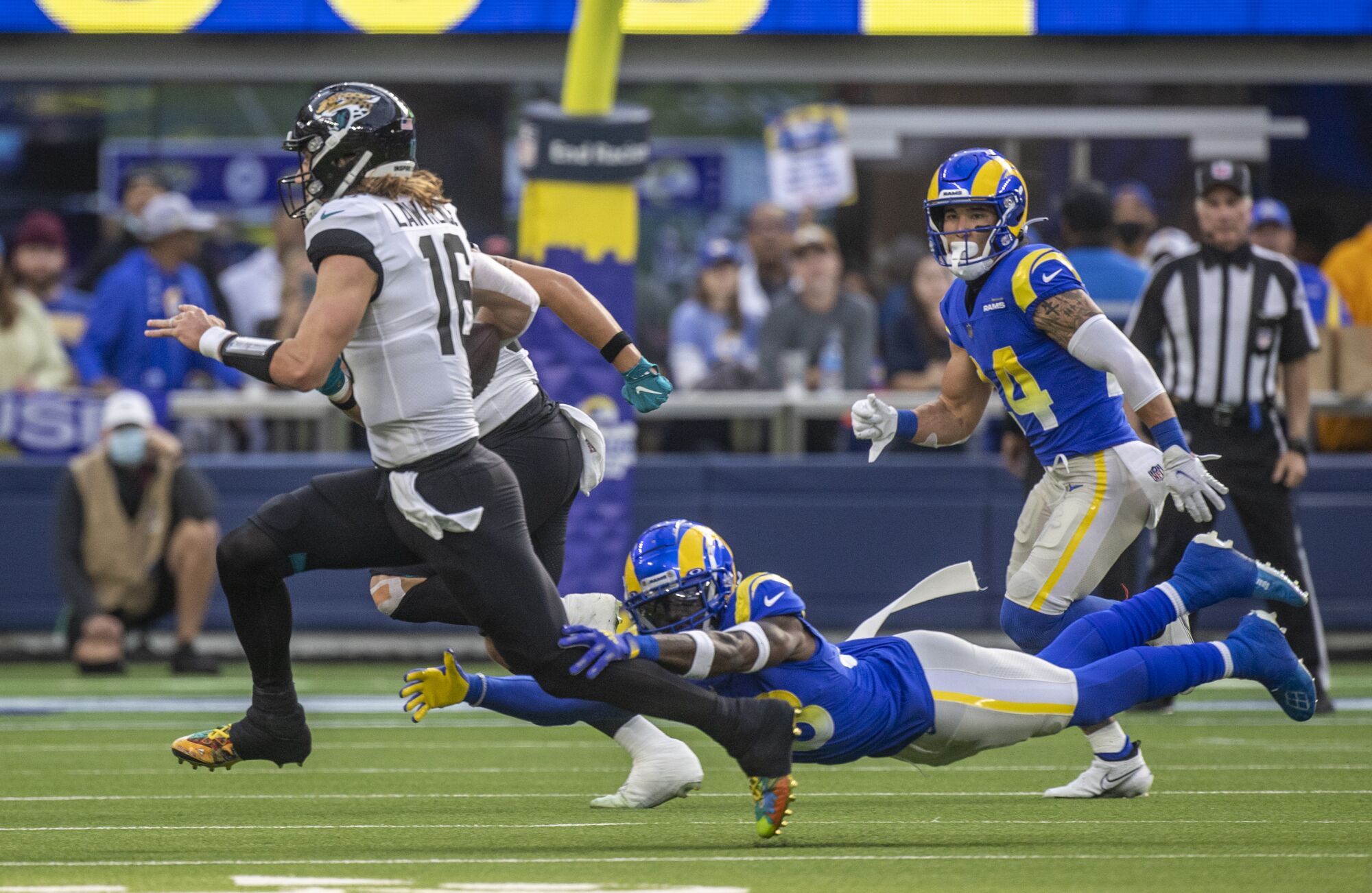 Rams safety Nick Scott dives to trip up Jacksonville Jaguars quarterback Trevor Lawrence.