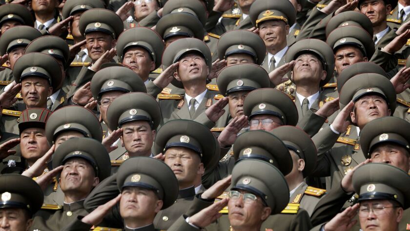 Soldiers salute as their national anthem is played during a military parade to celebrate the 105th birthday of Kim Il Sung, in Pyongyang, North Korea.