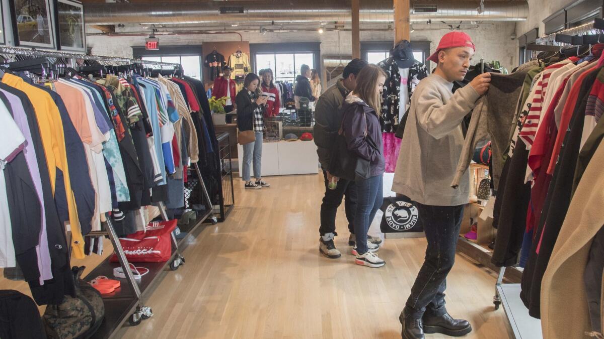 Shoppers check out clothing for sale in downtown Los Angeles. Reducing the number of new clothing items to eight or even three per person per year would help reduce greenhouse gas emissions tied to urban consumption.