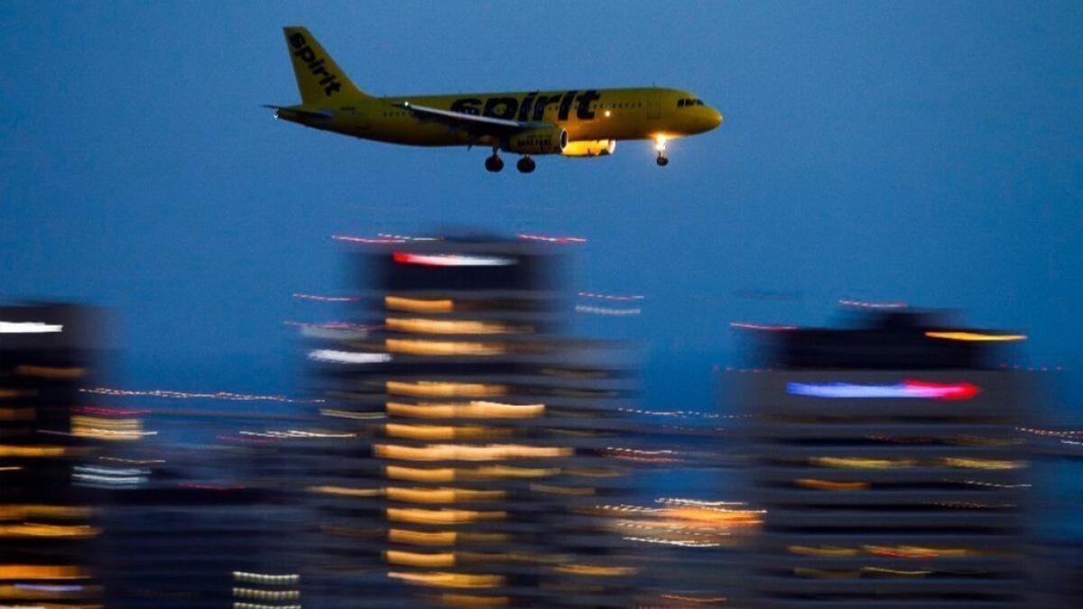 A Spirit Airlines jet flies past the downtown San Diego skyline as it comes in for a landing at San Diego International Airport. The airline changed its business plan to focus on passenger service and profits did not drop.