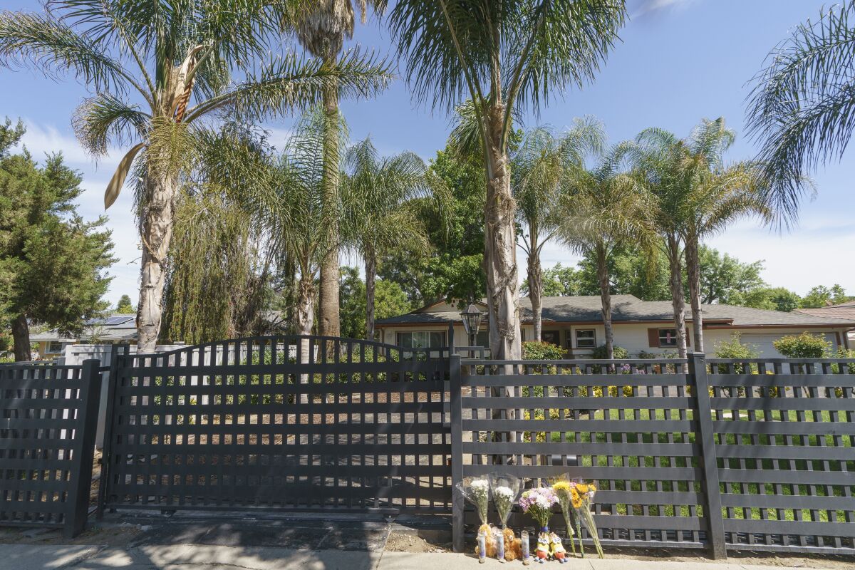 Flowers and teddy bears are left outside a ranch-style house in the West Hills neighborhood of the San Fernando Valley in Los Angeles, Monday, May 9, 2022. Police say three children were found dead at this Los Angeles home over the weekend and their mother and a teenager were arrested in the killings. (AP Photo/Damian Dovarganes)