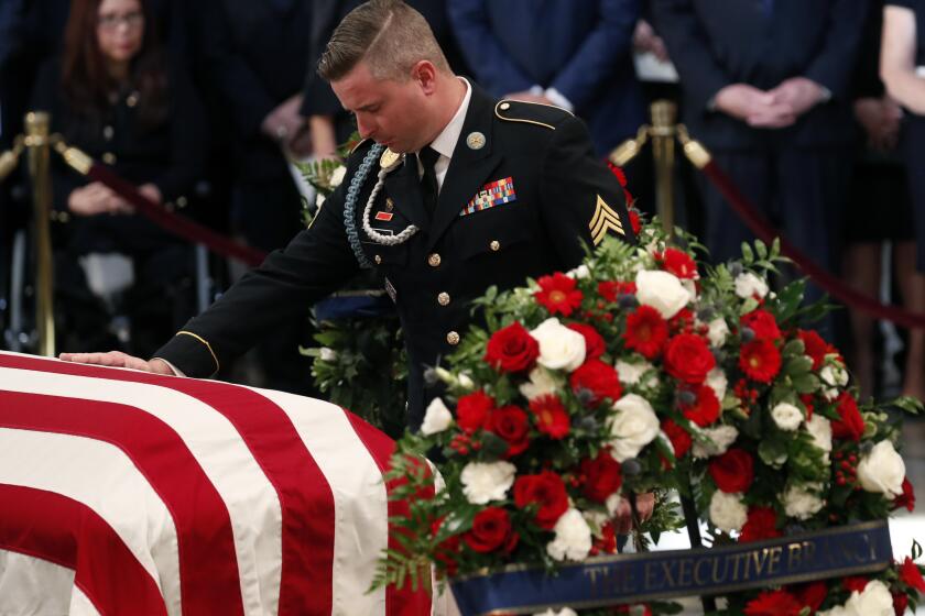 ARCHIVO - Jimmy McCain, hijo del senador por Arizona John McCain, toca el ataúd de su padre en una ceremonia en su honor el 31 de agosto de 2018, en la Rotonda del Capitolio, en Washington. (Kevin Lamarque/Foto compartida vía AP)