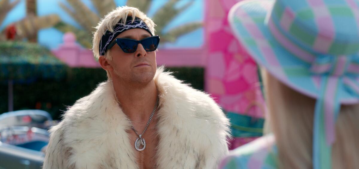 Ryan Gosling plays Ken in a white fur coat, a black bandana and black sunglasses in a still from the movie 'Barbie'