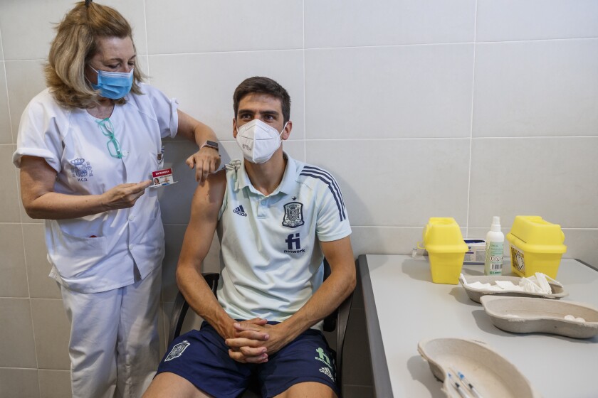 In this photo released by Spanish Soccer Federation (RFEF), Spain's Gerard Moreno receives a COVID-19 vaccine shot at Las Rozas Sports City in Madrid, Spain, Friday, June 11, 2021. Worried that a coronavirus outbreak could derail its chances at the European Championship, Spain sent in the army on Friday to vaccinate the national soccer team three days before its opening match at the tournament. Medics from Spain's Armed Forces administered the shots at the team's training facility near Madrid. (Pablo Garcia/RFEF via AP)