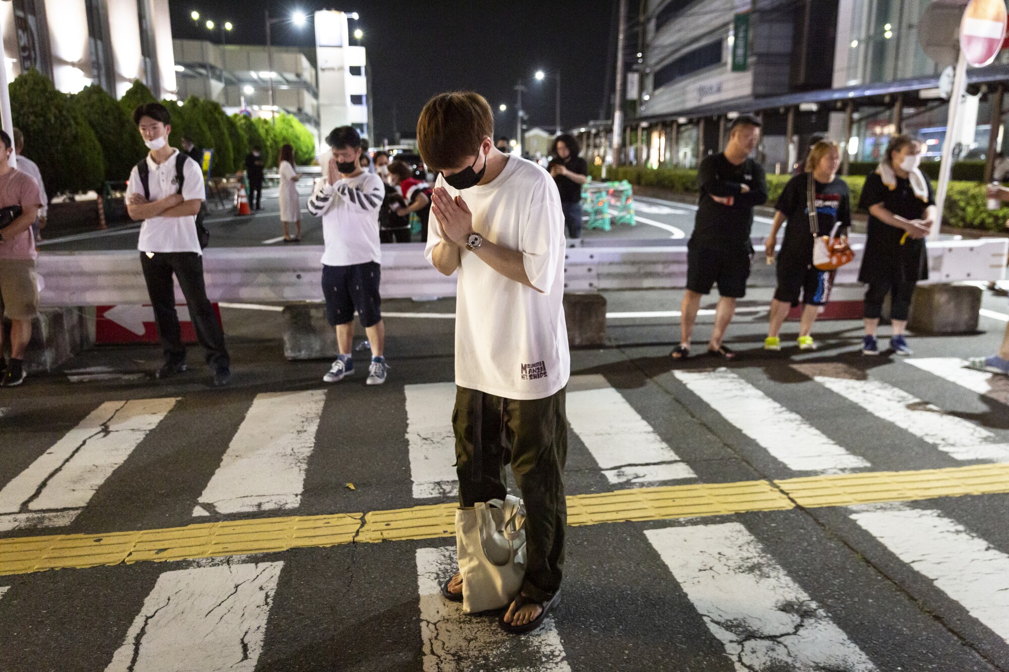 A man prays at a site outside of Yamato-Saidaiji Station where Japan’s former prime minister Shinzo Abe was shot