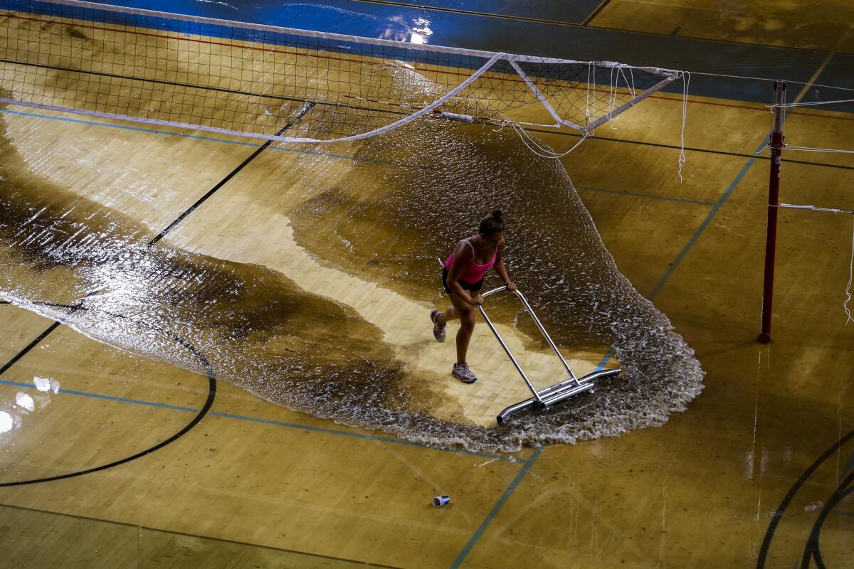 Water is removed from the court of Pauley Pavilion following flooding in July.