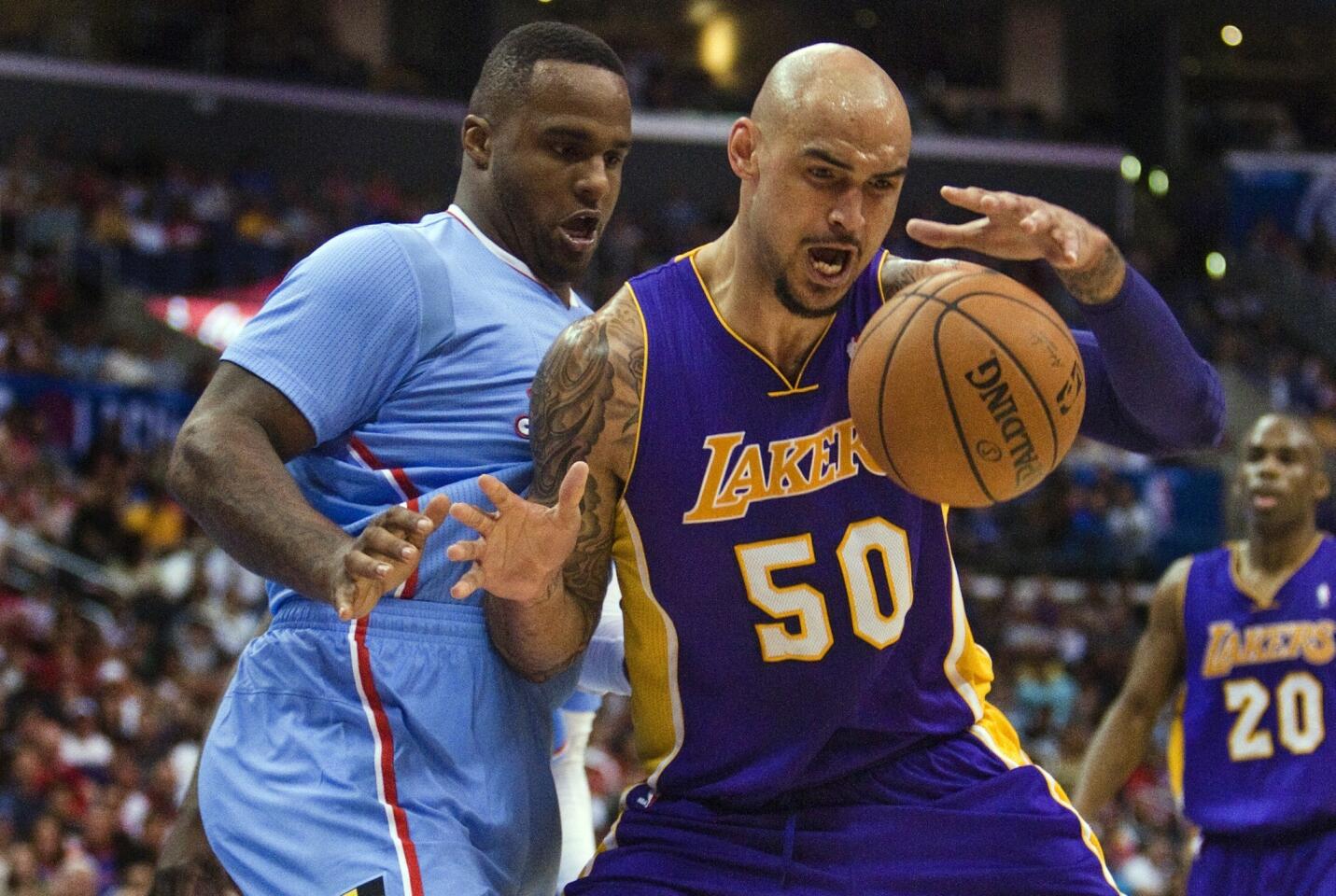 Lakers center Robert Sacre, right, beats Clippers forward Glen Davis for a rebound during the second half of the Clippers' 120-97 win at Staples Center.