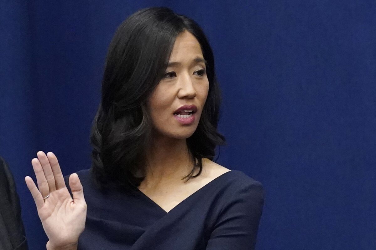 Michelle Wu raises her hand as she is sworn-in as Boston mayor.
