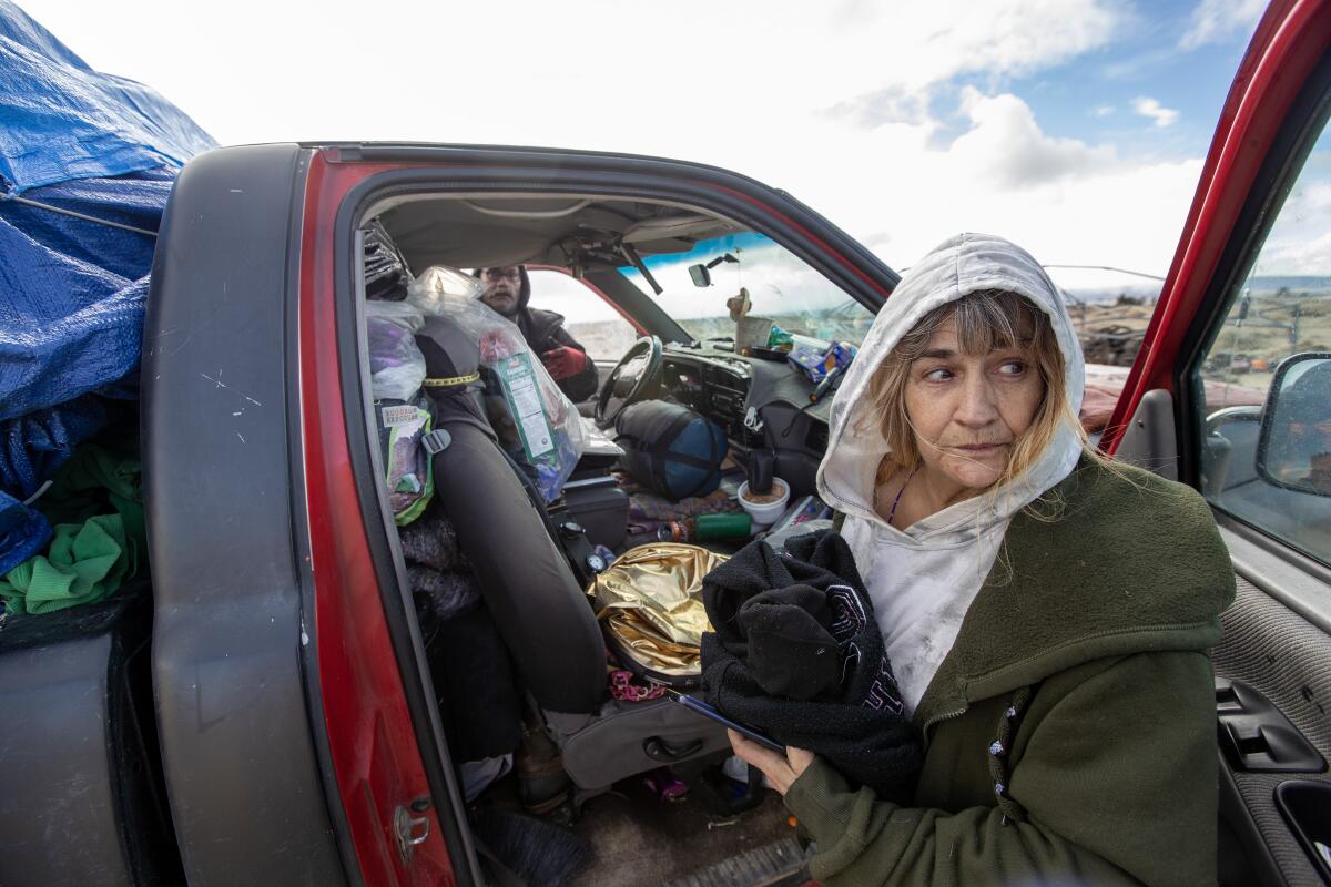 Two people pack up a truck with belongings 