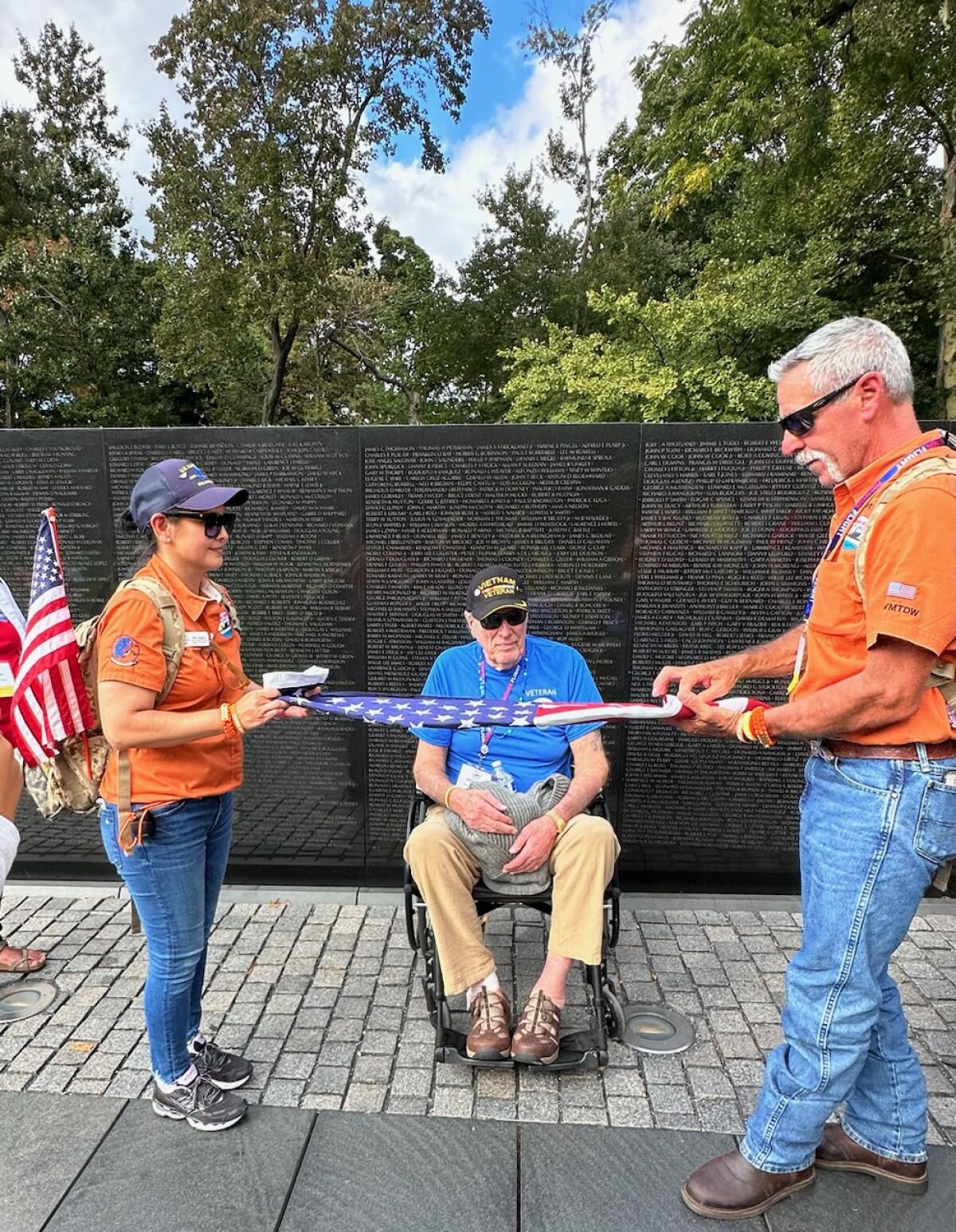 Honor Flight volunteers Dee Folse and Mel Taitano presented Vietnam veteran Larry Stretch with a flag.