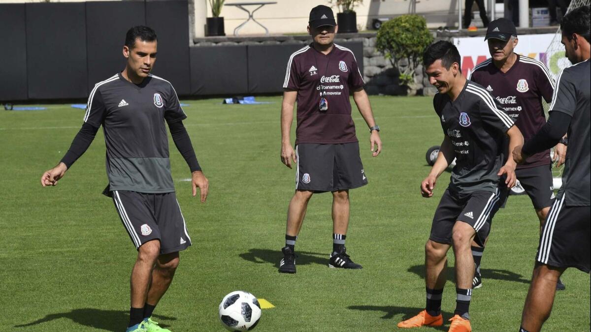 Mexican soccer player Rafael Marquez, left, wears a jersey without the logos of the team's corporate sponsors, who don't want to appear to do business with Marquez, who has been sanctioned by the U.S. Treasury Department.
