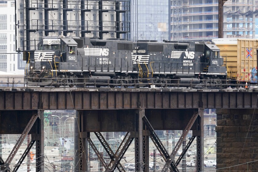 FILE - A Norfolk Southern freight train moves along elevated tracks in Philadelphia, Wednesday, March 31, 2021. Norfolk Southern railroad delivered 13% higher profit in the fourth quarter even though the amount of cargo it transported declined because it was able to raise rates. The Atlanta-based company said, Wednesday, Jan. 26, 2022, it earned $760 million, or $3.12 per share, in the quarter. (AP Photo/Matt Rourke, File)