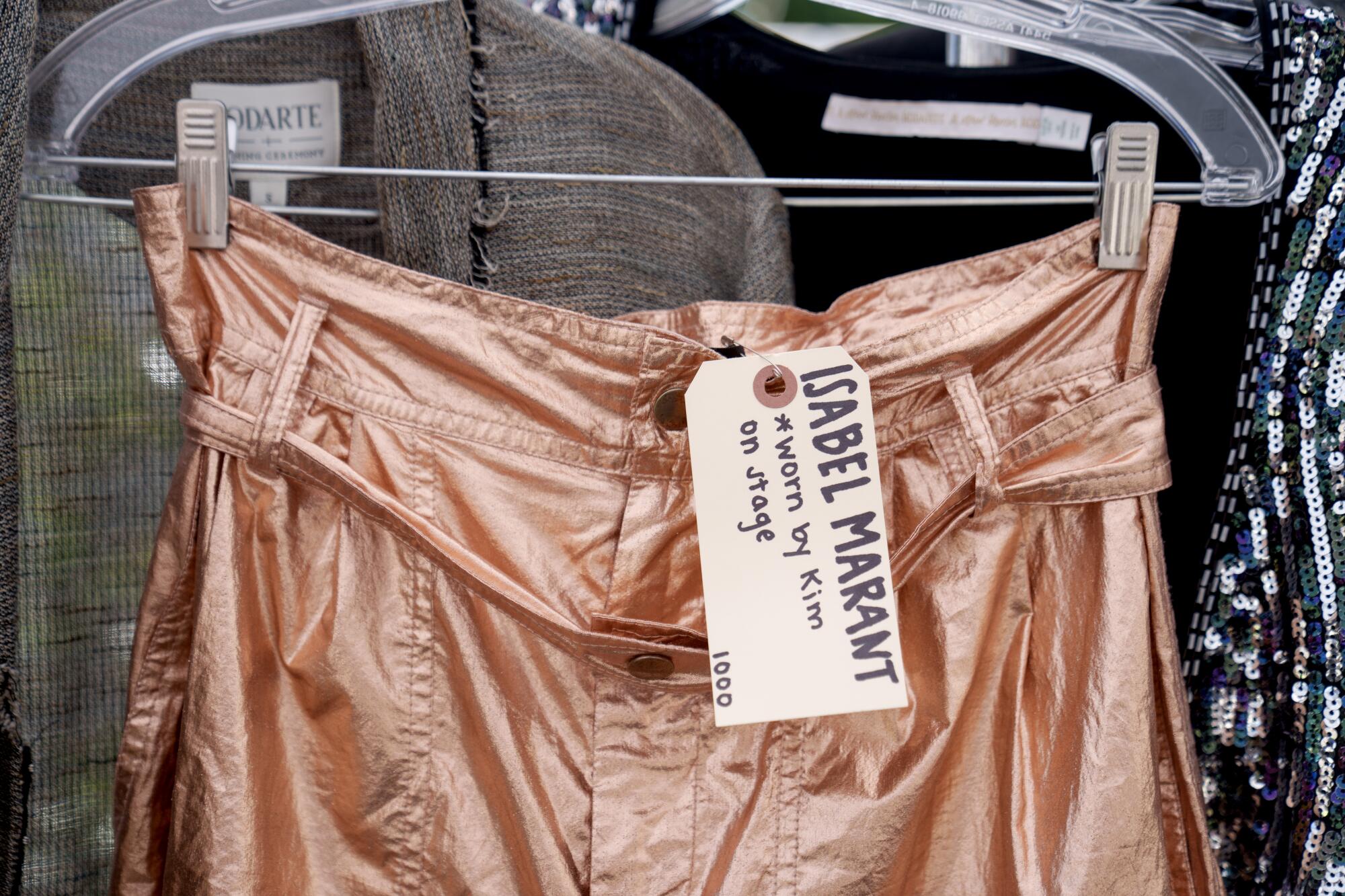 Metallic gold shorts on a hanger with a tag that says Isabel Marant