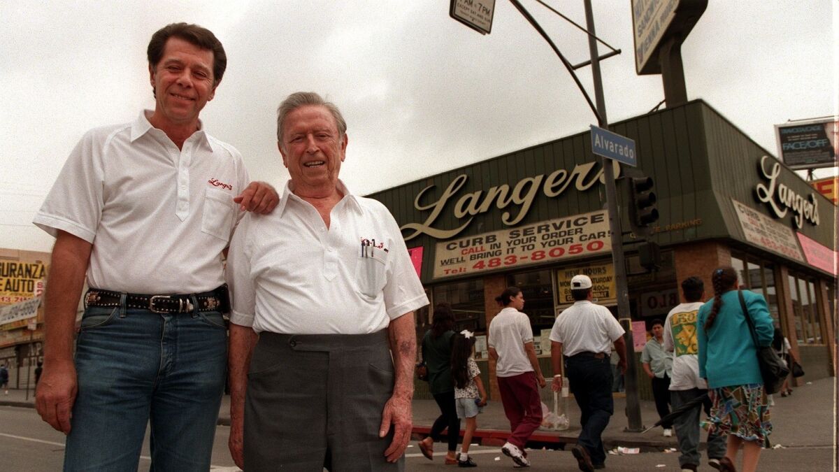 Norm Langer, left, with his father, Al, in front of Langer's Deli in 1997.