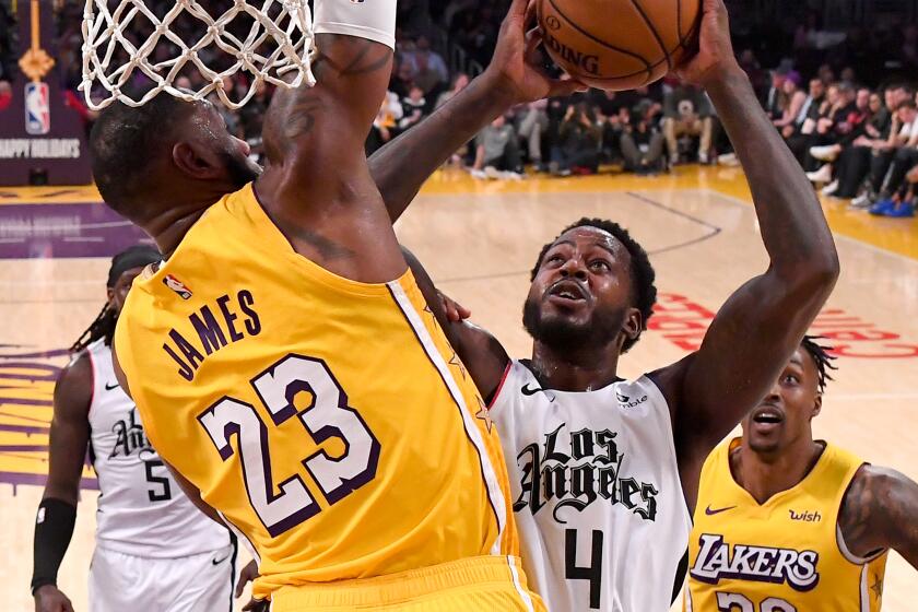 Clippers forward JaMychal Green tries to score inside against Lakers forward LeBron James during the second half of a game Dec. 25, 2019, at Staples Center.