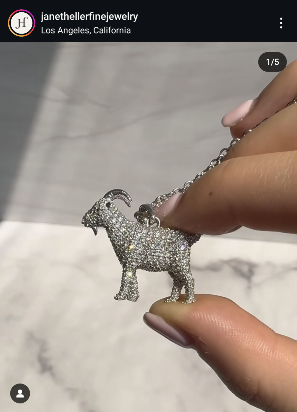 A photo shows the diamond-encrusted goat pendant created for Olympic star Simone Biles by Janet Heller Fine Jewelry