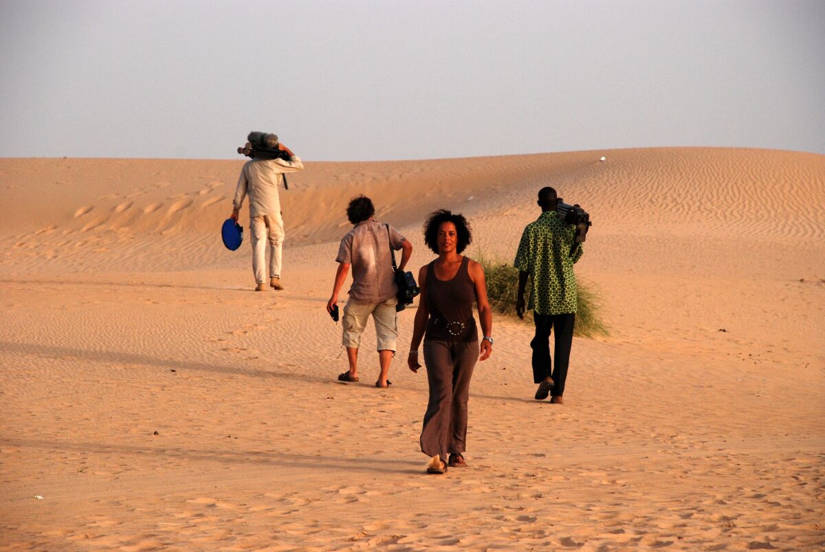 A woman walks in the sand.