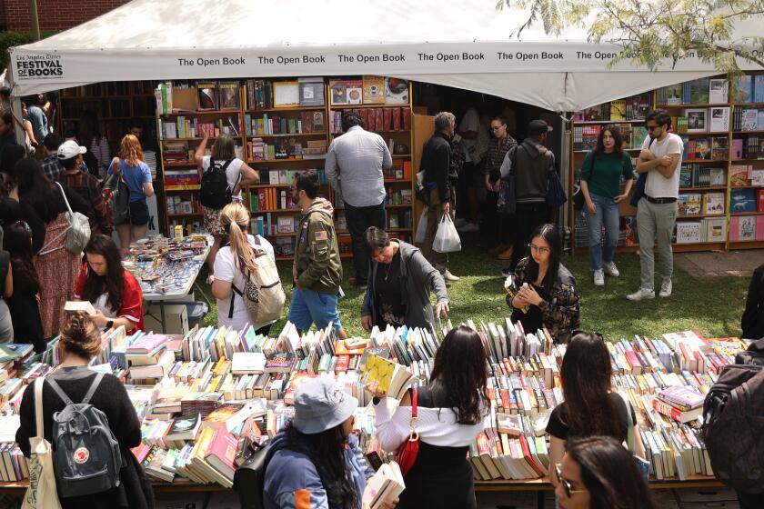 Los Angeles , CA - April 19: People look through an array of books to purchase during the LA Times Book Festival at USC campus on Friday, April 19, 2024 in Los Angeles, CA. (Michael Blackshire / Los Angeles Times)