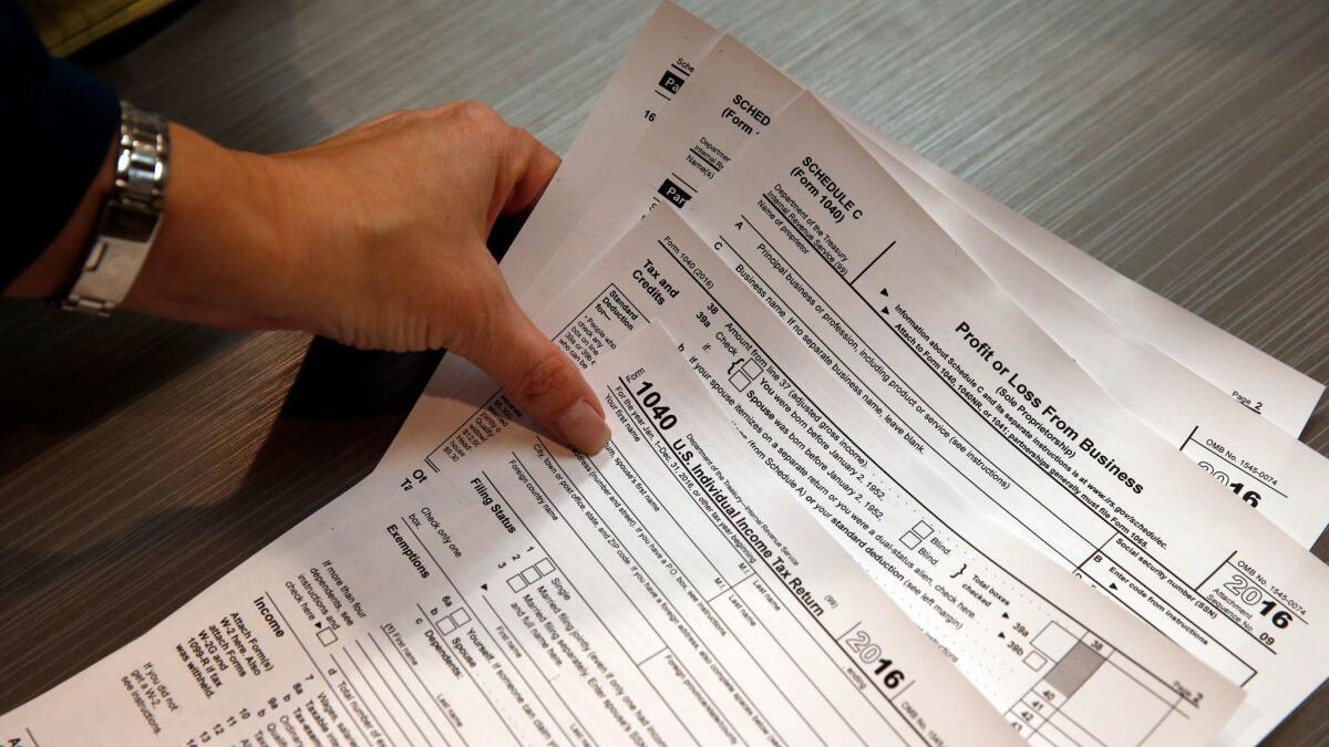A tax professional reaches for hard copies of tax forms in 2017.