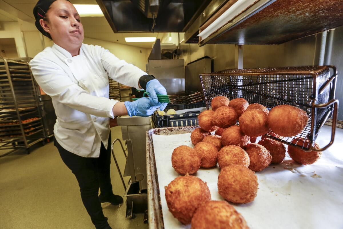 Mara Serrano fries potato balls at Porto's Bakery & Cafe in Glendale.