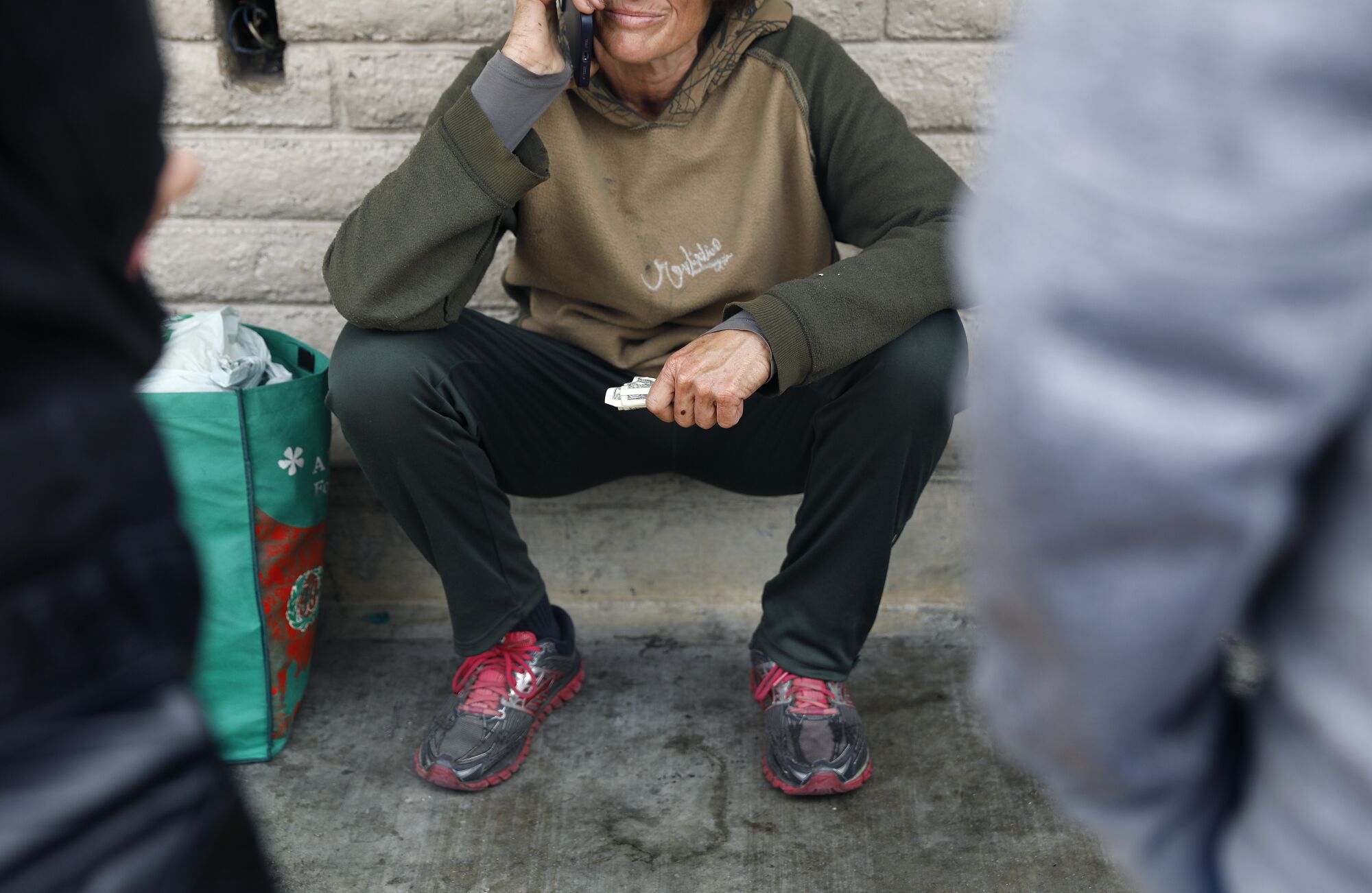 Sherry Hill's daughter, right, talks to her mother on the phone outside of a 7-Eleven in Pasadena