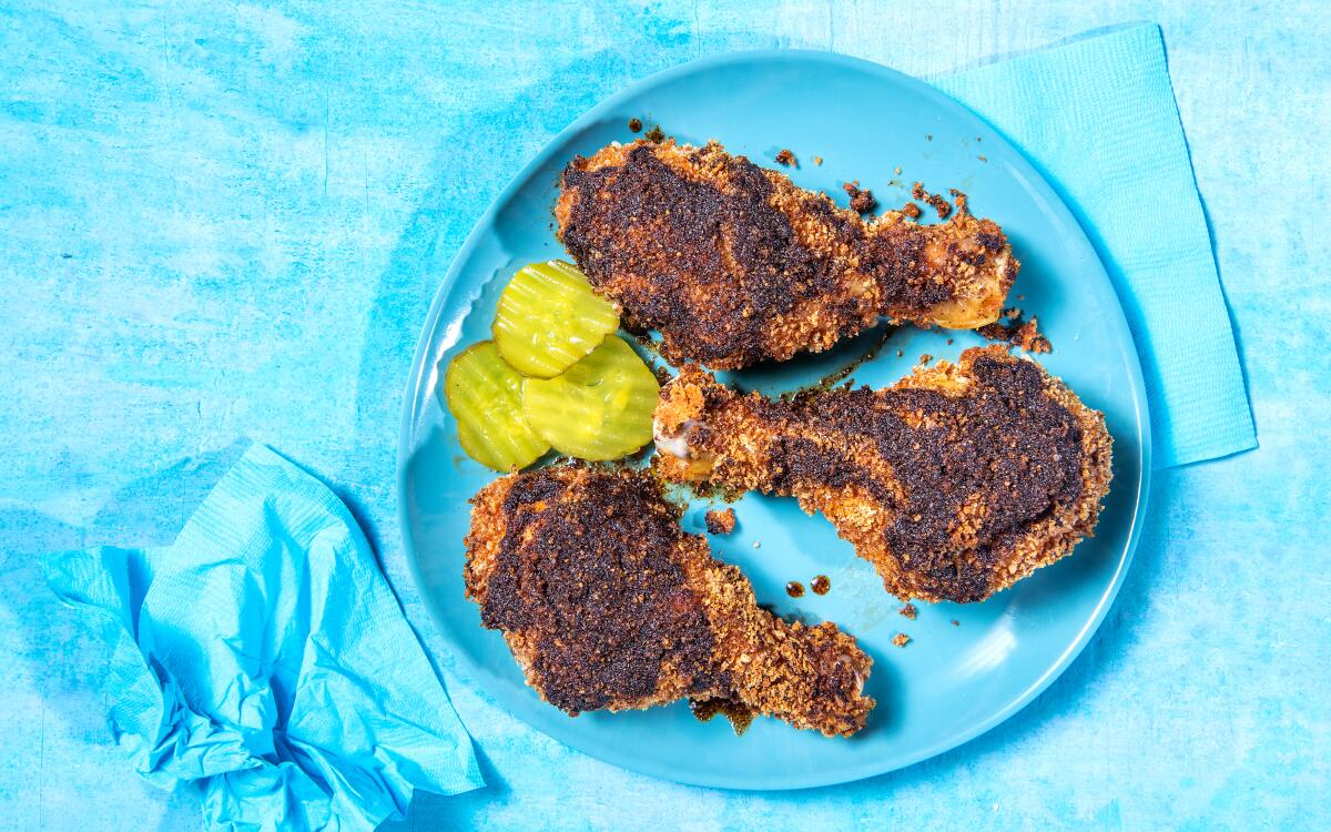 Three Nashville-Style Hot Chicken drumsticks, served with pickles for a bright bite to balance the heat of the chicken.