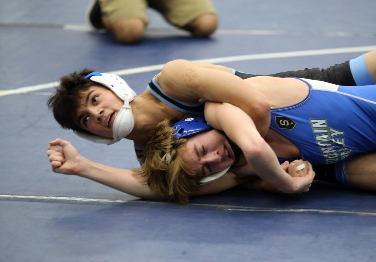 Corona del Mar's Luke Villaluz, left, and Fountain Valley's Kade Ayres compete in a 126-pound semifinal match during the Sunset Conference wrestling finals at Corona del Mar High School on Saturday.